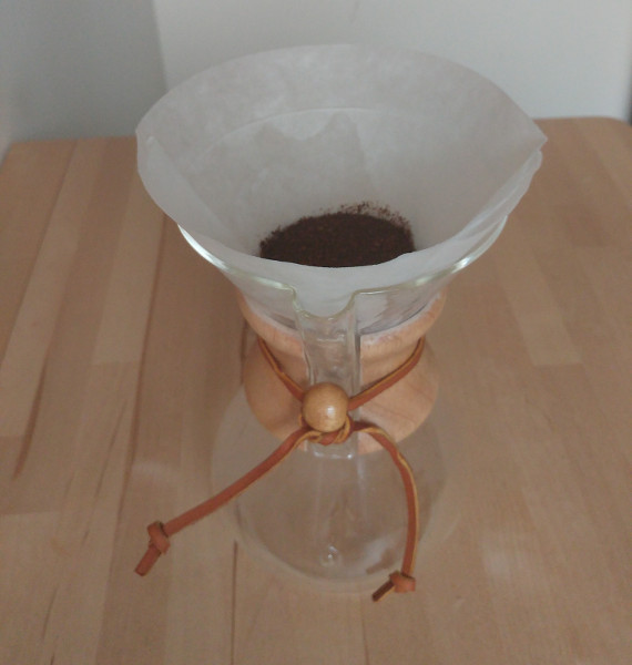 Chemex with a filter paper prepared and coffee grounds added